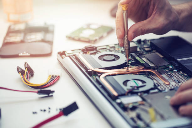 Home technician repairing laptop computer closeup